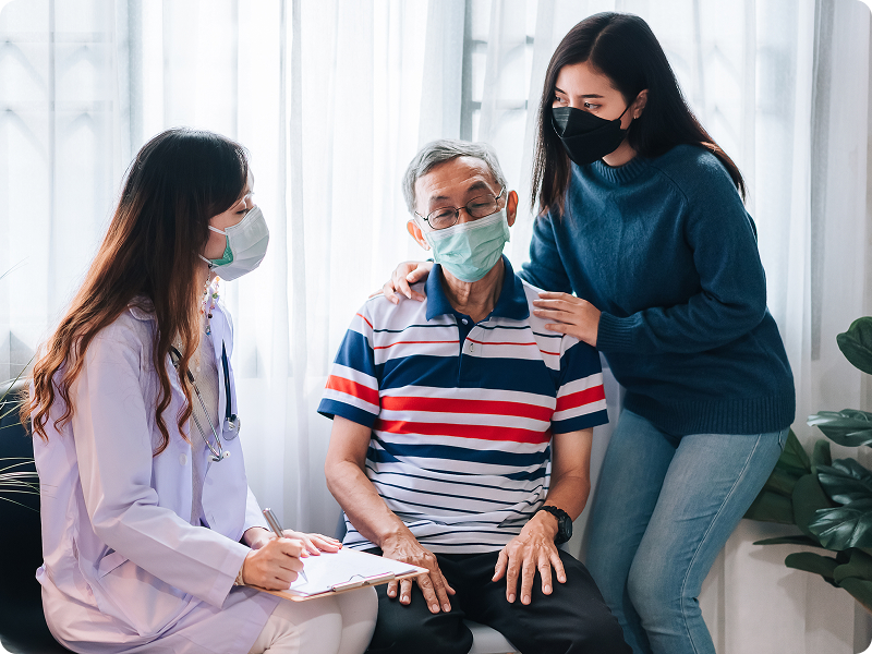 Family physician talking to an elderly couple in a clinic.