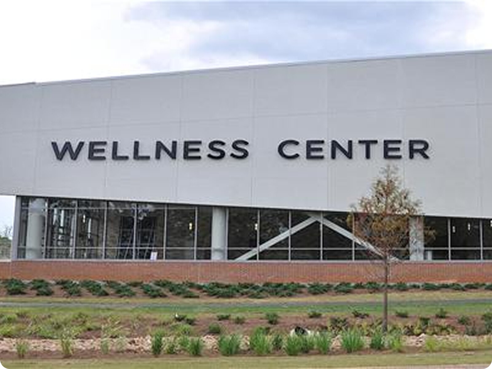 The exterior of a modern, multi-story commercial building with a sign that reads "Wellness Center."
