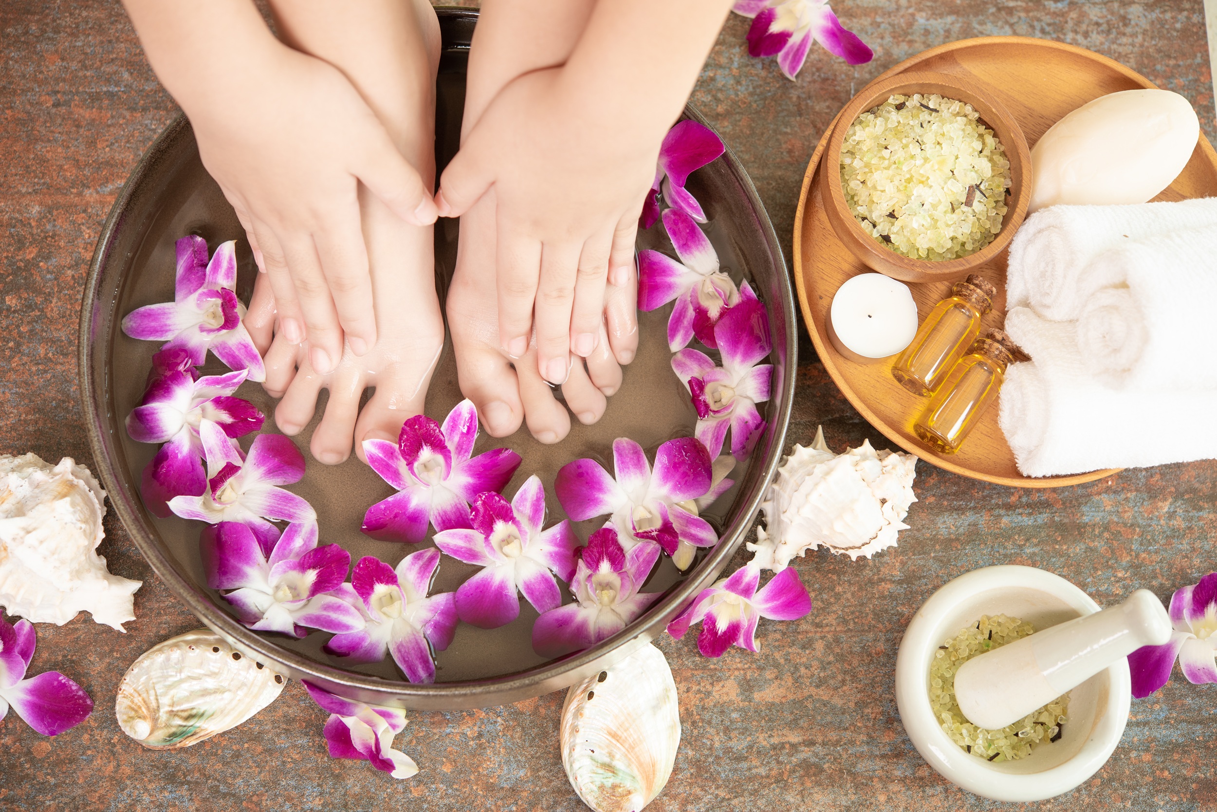 Client receiving a relaxing foot spa treatment with flower decoration in a wellness spa