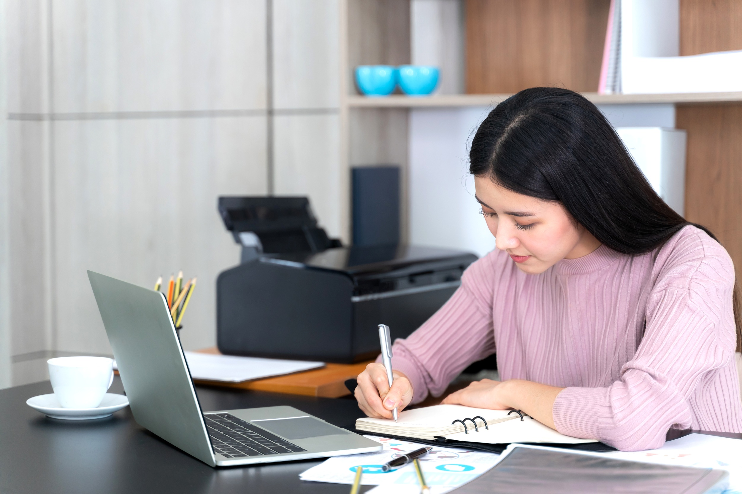 Content marketer writing SEO blog content with long-tail keyword research on a laptop